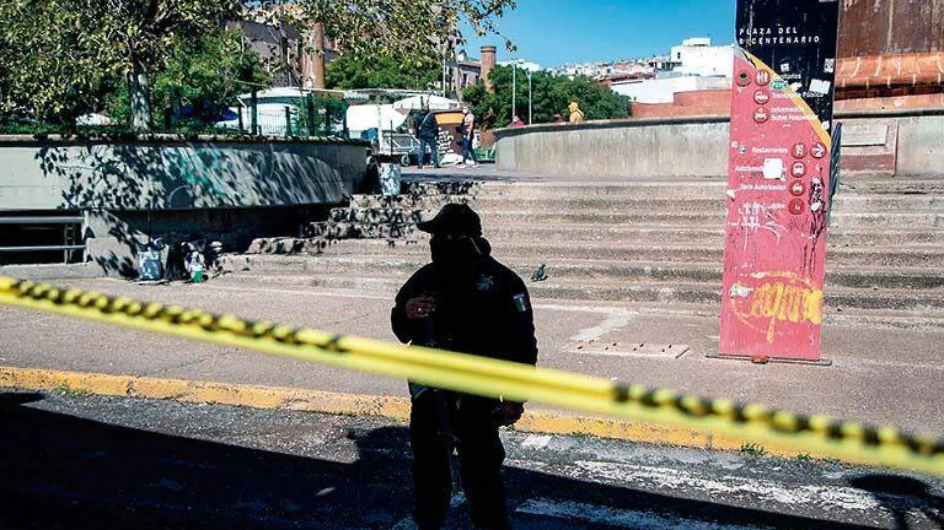 Elemento policiaco cuida zona acordonada en la Plaza Bicentenario donde fueron asesinadas dos personas